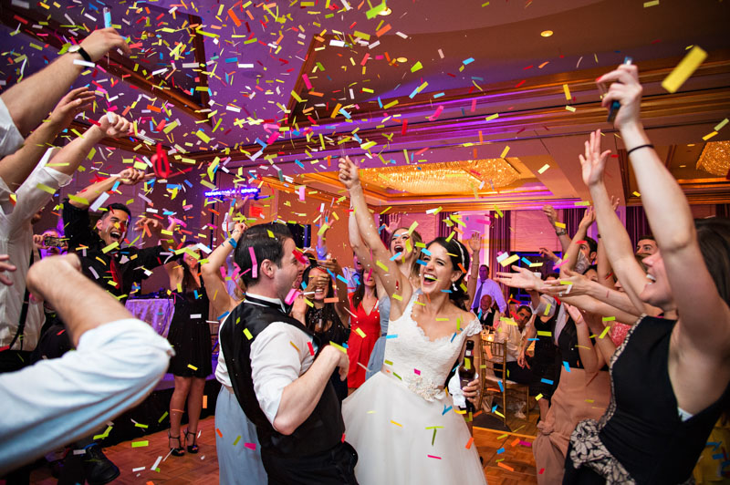 Couple dancing while Wedding Party throws Confetti at a reception