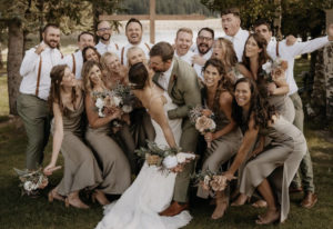 Marty and Ashlynn share a kiss after getting married with their wedding party in the background.