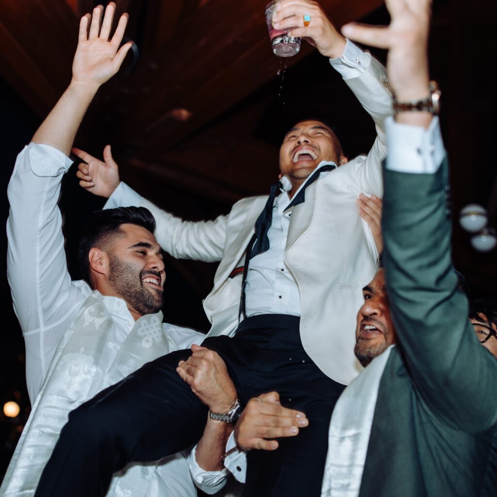 Groom being lifted in the air by guests during an unforgettable wedding party created by a Denver wedding DJ.