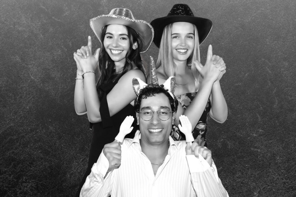Wedding guests pose in a luxury black and white glam photo booth.
